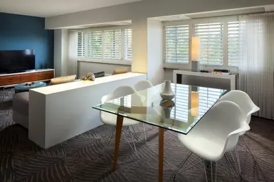 a living room with a glass table and white chairs at W Los Angeles – West Beverly Hills in Los Angeles