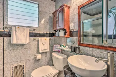 a bathroom with a toilet and a sink and a mirror at 1 Mi to Lake Gregory Boho Crestline Cabin in Crestline