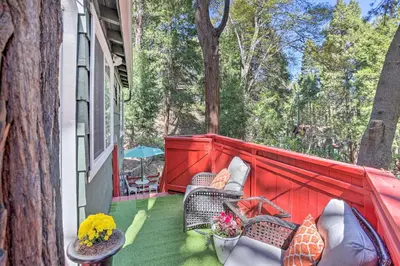 a porch with two chairs and a red fence at 1 Mi to Lake Gregory Boho Crestline Cabin in Crestline
