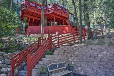 a red tree house with stairs and a bench at 1 Mi to Lake Gregory Boho Crestline Cabin in Crestline