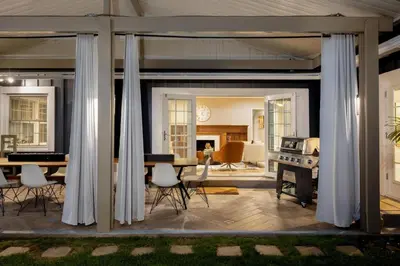 a living room with white curtains and a dining room at Hidden Valley PL in Los Angeles