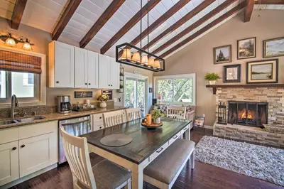 a kitchen with a table and a fireplace at Tree-Lined Twin Peaks Cottage with Custom Stream in Twin Peaks