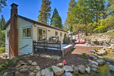 a tiny house with a deck and a patio at Tree-Lined Twin Peaks Cottage with Custom Stream in Twin Peaks
