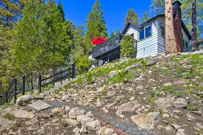 a house with a red umbrella on top of a hill at Tree-Lined Twin Peaks Cottage with Custom Stream in Twin Peaks