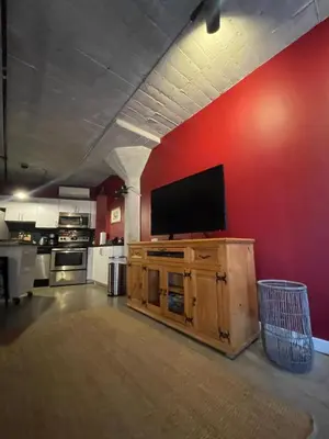 a living room with a flat screen tv on a red wall at BO-BOU Suite in Los Angeles