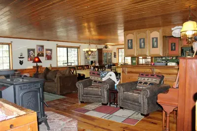 a living room with couches chairs and a stove at The Old Bear BnB in Pine Mountain Club