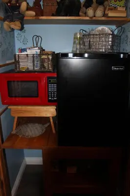 a red microwave sitting next to a black refrigerator at The Old Bear BnB in Pine Mountain Club