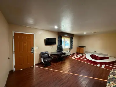 a living room with a bed and a table and a television at Rocky Inn Motel Long Beach, CA in Long Beach