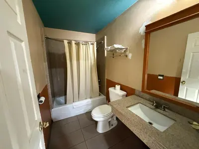 a bathroom with a toilet and a sink and a shower at Rocky Inn Motel Long Beach, CA in Long Beach