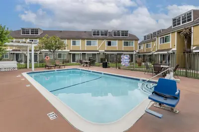 a swimming pool with a blue chair in front of a building at Best Western Westminster Inn in Westminster