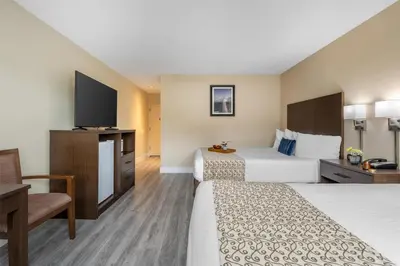 a hotel room with two beds and a flat screen tv at Best Western Westminster Inn in Westminster