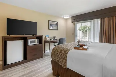 a hotel room with a bed and a flat screen tv at Best Western Westminster Inn in Westminster