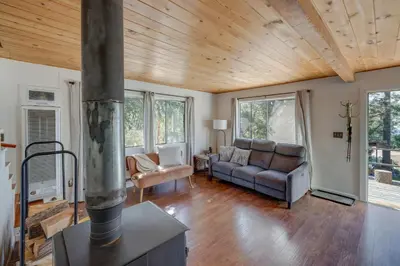 a living room with a couch and a stove at Quiet Sequoia National Forest Cabin with Fireplace in Posey
