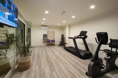 a gym with two treadmills and two exercise bikes at Hotel Huntington in Duarte