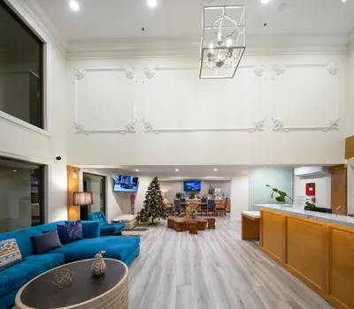 a living room with a blue couch and a christmas tree at Hotel Huntington in Duarte