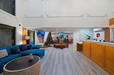a living room with a blue couch and a christmas tree at Hotel Huntington in Duarte