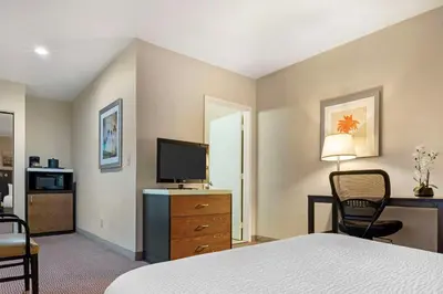 a hotel room with a bedroom with a bed and a television at Best Western Royal Palace Inn & Suites in Los Angeles