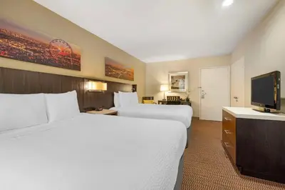 a hotel room with two beds and a flat screen tv at Best Western Royal Palace Inn & Suites in Los Angeles
