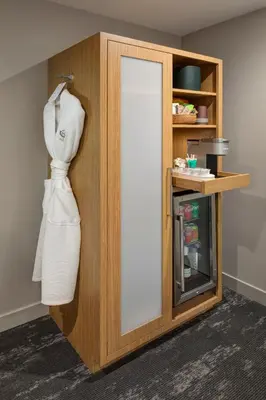 a white dress hanging on a cabinet with a mirror at Olivia Hotel in Los Angeles