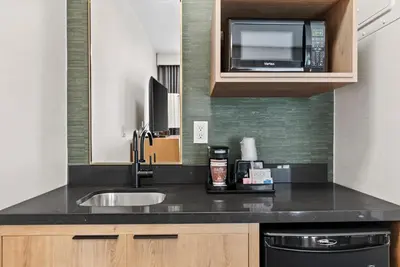a kitchen with a sink and a microwave at Royal Palace Westwood Hotel in Los Angeles