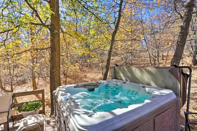 a hot tub on a deck with trees in the background at Lake Arrowhead Studio Near Hiking with Hot Tub in Lake Arrowhead