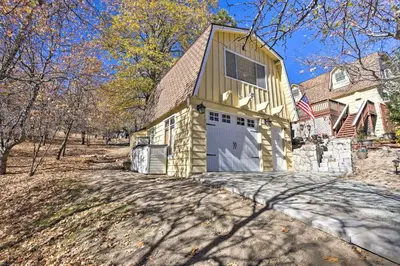 a house with a garage with a flag on it at Lake Arrowhead Studio Near Hiking with Hot Tub in Lake Arrowhead