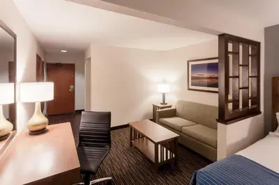 a hotel room with a bed and a couch at Holiday Inn Express & Suites Carpinteria by IHG in Carpinteria