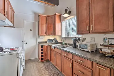 a kitchen with wooden cabinets and a white refrigerator at Modern Cabin with Game Room and Deck, Near Skiing in Running Springs