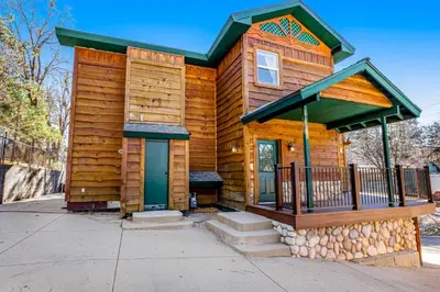 a log cabin with a porch and a front door at Running Springs R-n-R in Running Springs