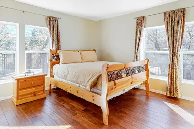 a bedroom with a bed and two windows at Running Springs R-n-R in Running Springs