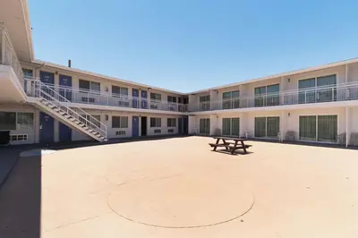 an empty courtyard of an apartment building with a bench at Motel 6-Barstow, CA - Route 66 in Barstow