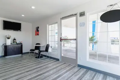 a waiting room with a table and chairs and windows at Motel 6-Barstow, CA - Route 66 in Barstow
