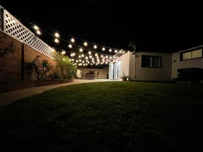 a string of lights on the side of a house at night at Cheerful, Beautifully Remodeled, Modern, Comfortable Home in Los Angeles