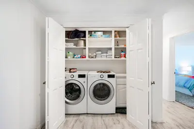 a white laundry room with a washer and dryer at Sandcastle by the Sea in Oxnard
