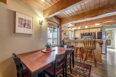 a dining room and kitchen with a wooden table and chairs at Adorable Explorable in Lake Arrowhead
