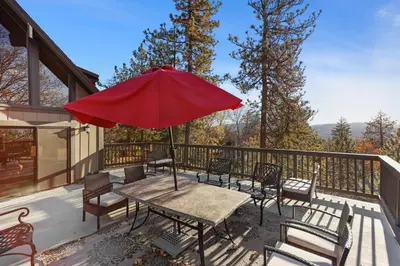 a patio with a table and chairs and an umbrella at Howard's Cabin in Lake Arrowhead