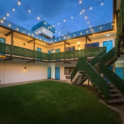 a building with a staircase and a lawn with lights at Casa Playa Inn - Stanton, Anaheim in Stanton