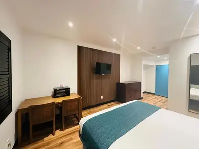 a bedroom with a bed and a desk with a television at Casa Playa Inn - Stanton, Anaheim in Stanton