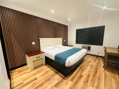 a bedroom with a bed and a flat screen tv at Casa Playa Inn - Stanton, Anaheim in Stanton