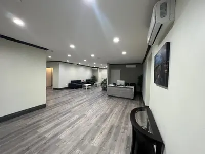 a living room with a couch and a tv on a wall at ASPIRE INN & SUITES Orange in Orange