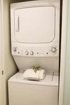 a washer and dryer with a towel on top of it at Classic Los Angeles Elegance in Downtown, Sleeps 4, Free Parking and 360 Degree View Roof Top Pool! in Los Angeles