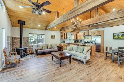a living room with wooden ceilings and a fireplace at Cozy Pine Mountain Club Cabin with Large Deck in Pine Mountain Club
