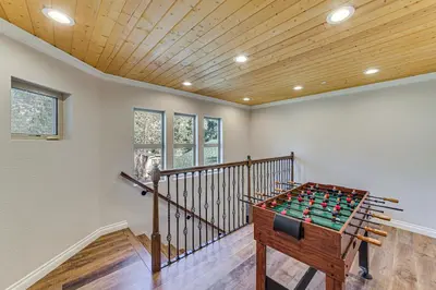a room with a foosball table in front of a staircase at Cozy Pine Mountain Club Cabin with Large Deck in Pine Mountain Club