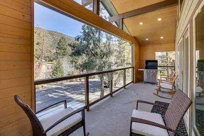 a screened in porch with two chairs and a table at Cozy Pine Mountain Club Cabin with Large Deck in Pine Mountain Club