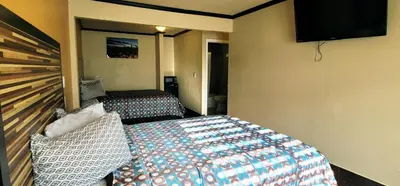 a hotel room with two beds and a flat screen tv at RUBY MOTEL in Long Beach