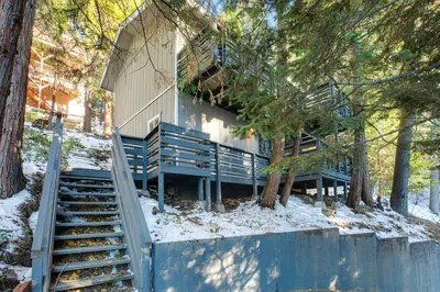 a house with a staircase in the woods at Arrowhead Aerie in Lake Arrowhead