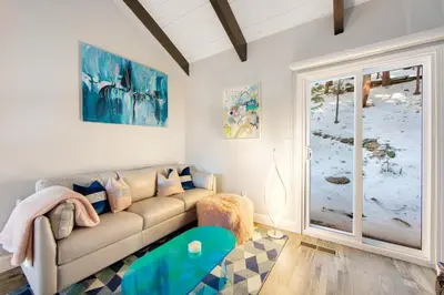 a living room with a couch and a sliding glass door at Arrowhead Aerie in Lake Arrowhead