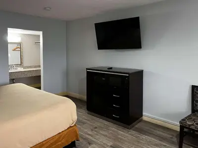 a hotel room with a bed and a flat screen tv at Studio 6 Artesia CA in Artesia