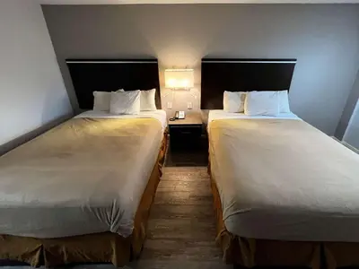 a hotel room with two beds and a lamp at Studio 6 Artesia CA in Artesia