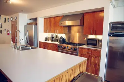 a kitchen with wooden cabinets and a white counter top at STAY OPEN Venice Beach in Los Angeles